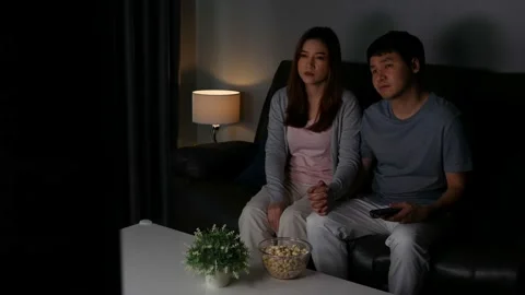 Crying young couple watching romantic movie TV on sofa at night Stock Footage 154843916
