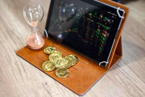 Crypto currency and graph analysis on tablet and hourglass Stock Photos
