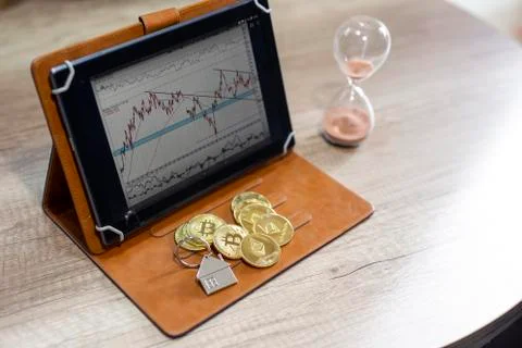 Crypto currency bitcoin on table with tablet and hourglass Stock Photos