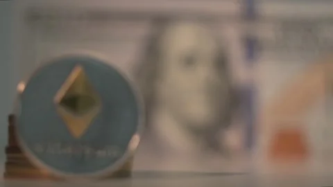 Crypto currency. Silver Etherium coin with gold logo and USA dollar. Focus shift Stock Footage 134521978