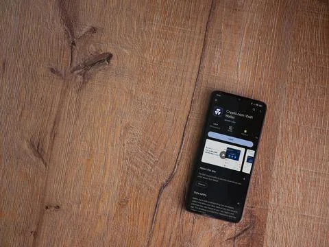 Crypto.com app play store page on smartphone on wooden background Stock Photos