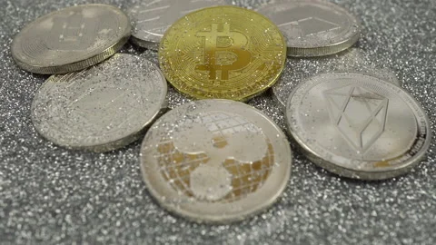 Cryptocurrencies lie on silver sequins. Real coins. The camera moves to the Stock Footage 155356888