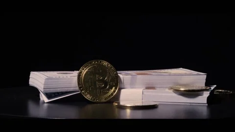 Cryptocurrency and stacks of hundred dollar bills slowly rotating with Stock Footage 217947234