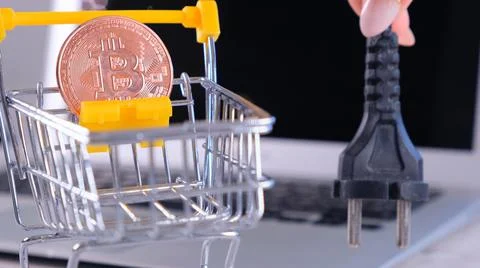 Cryptocurrency Bitcoin with power supply socket. Hand holding plug have computer Stock Photos