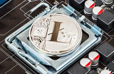Cryptocurrency Litecoin lying over electronic computer component. Business co Stock Photos
