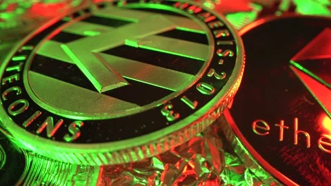 Cryptocurrency Litecoin in Macro shot rotate with many other coins. Green and Video stock 142313783