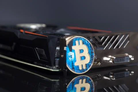 Cryptocurrency mining concept with blue bitcoin on a videocard Stock Photos