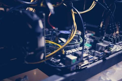 Cryptocurrency mining rig PCIe riser extenders plugged to motherboard. Stock Photos