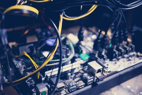 Cryptocurrency mining rig PCIe riser extenders plugged to motherboard. Stock Photos