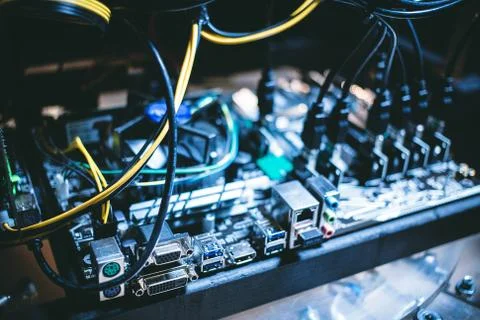 Cryptocurrency mining rig PCIe riser extenders plugged to motherboard. Stock Photos