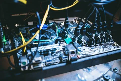 Cryptocurrency mining rig PCIe riser extenders plugged to motherboard. Stock Photos