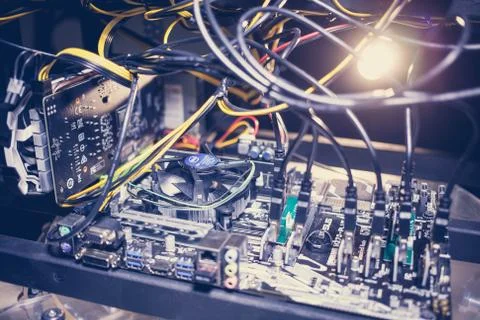 Cryptocurrency mining rig PCIe riser extenders plugged to motherboard. Stock Photos