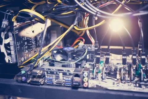 Cryptocurrency mining rig PCIe riser extenders plugged to motherboard. Stock Photos