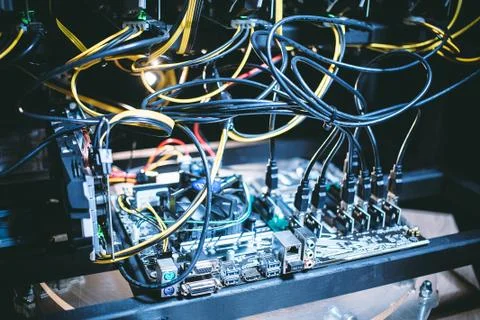Cryptocurrency mining rig PCIe riser extenders plugged to motherboard. Stock Photos