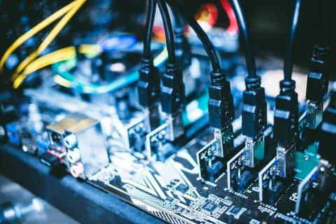 Cryptocurrency mining rig PCIe riser extenders plugged to motherboard. Stock Photos