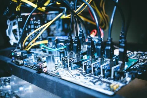 Cryptocurrency mining rig PCIe riser extenders plugged to motherboard. Stock Photos