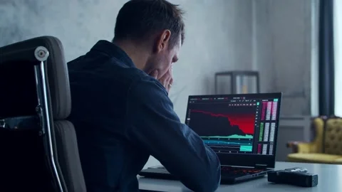 Cryptocurrency Trader at his Workplace in front of a Computer. Man Commits Stock Footage 195083948