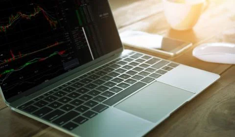 CryptoCurrency Trading laptop on work table. Stock Photos