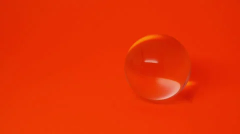 Crystal Ball Rolls into Orange Background Stock Footage 27806372