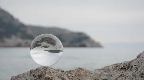Crystal ball on the sea side rocks Stock Footage 63684440