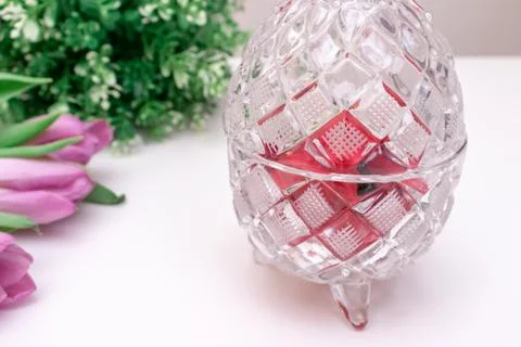 Crystal bowl in the shape of easter eggs with spring flowers tulipsn and a pl Stock Photos