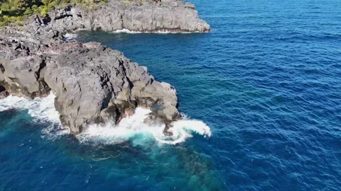 Crystal Clear Blue Ocean and Rocky Cape Aerial Top Down Stock Footage 329060544