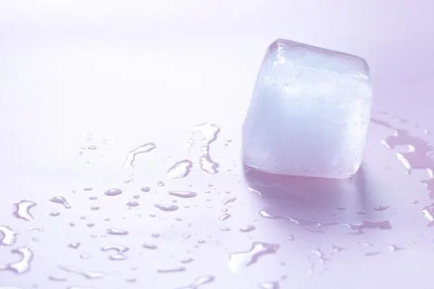 Crystal clear ice cube on light pink background, space for text 스톡 사진
