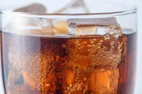 Crystal clear ice cubes floating in refreshing cola beverage with carbonati.. Stock-Fotos
