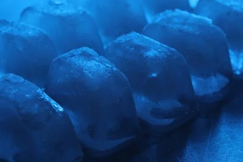 Crystal clear ice cubes on light blue background, closeup. Color tone effect Foto stock