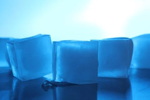 Crystal clear ice cubes on light blue background, closeup. Color tone effect Foto stock