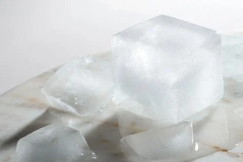 Crystal clear ice cubes on light grey marble board, closeup Foto stock