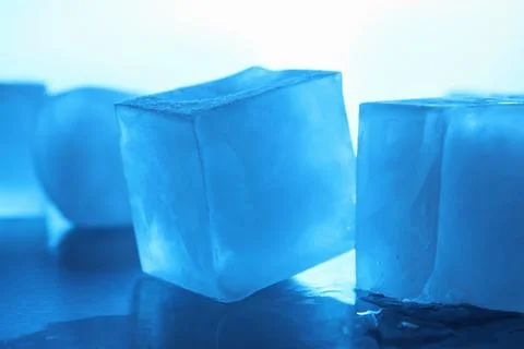 Crystal clear ice cubes on light blue background, closeup. Color tone effect Stock Photos