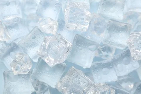 Crystal clear ice cubes on light blue background, flat lay Foto stock