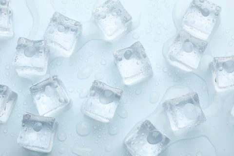 Crystal clear ice cubes on light blue background, flat lay Foto stock