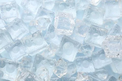 Crystal clear ice cubes on light blue background, flat lay Foto stock
