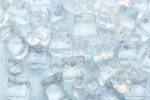 Crystal clear ice cubes on light blue background, flat lay Stock Photos