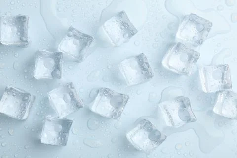 Crystal clear ice cubes on light blue background, flat lay Stock Photos