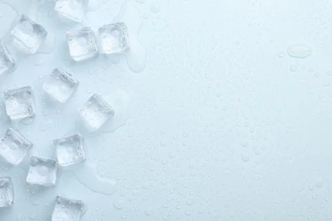 Crystal clear ice cubes on light blue background, flat lay. Space for text 스톡 사진