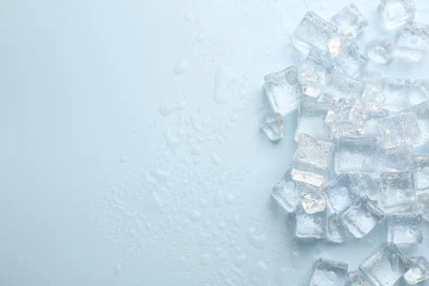 Crystal clear ice cubes on light blue background, flat lay. Space for text 스톡 사진