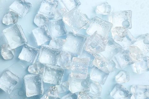 Crystal clear ice cubes on light blue background, flat lay Foto stock