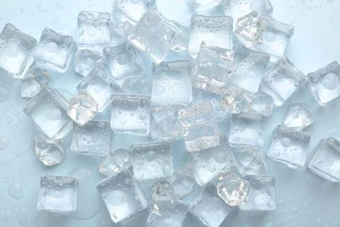 Crystal clear ice cubes on light blue background, flat lay Stockfoto's