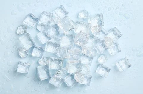 Crystal clear ice cubes on light blue background, flat lay Stock Photos