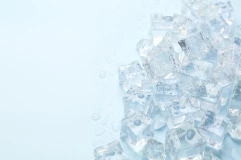 Crystal clear ice cubes on light blue background, flat lay. Space for text 스톡 사진
