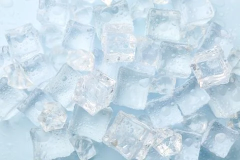 Crystal clear ice cubes on light blue background, flat lay Foto stock