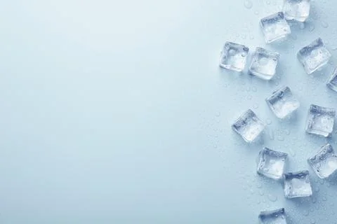 Crystal clear ice cubes on light blue background, flat lay. Space for text Foto stock