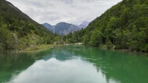 Crystal-Clear Lake in a Mountain Valley – Mirror Reflection of Tree Line Stock Footage 293481691