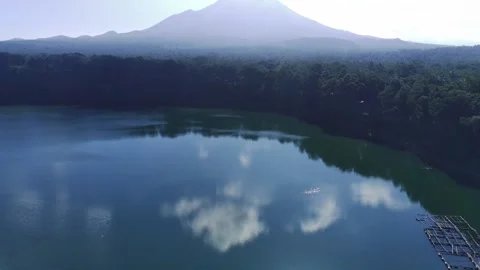 A crystal clear lake reflects a dramatic mountain range. Lush green forest Stock-Footage 270098196