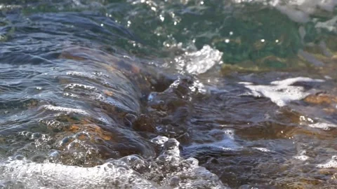 Crystal clear ocean water flowing over wet rocky coastal stones Stock Footage 337409400