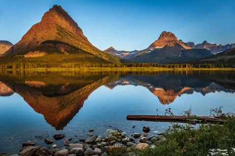 Crystal Clear Reflections of the Mountains on Swiftcurrent Lake, Many Glacier Foto stock