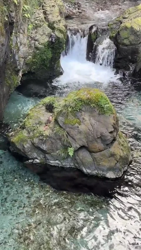 Crystal clear river flowing through rocky canyon with small waterfall and lush Vidéo 334163476